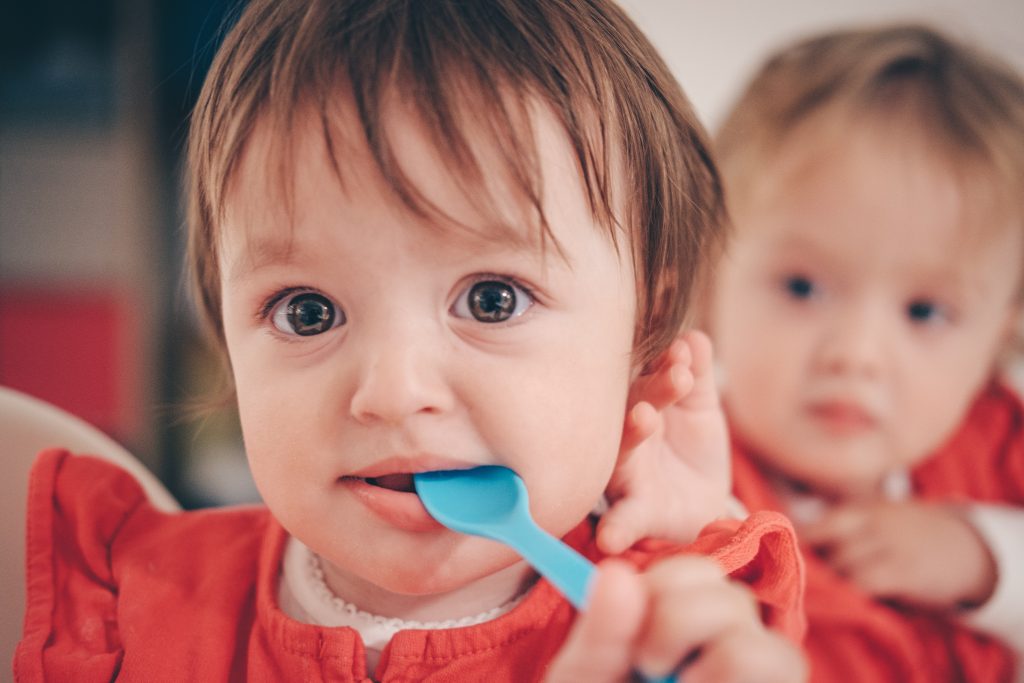 Enfants jumeaux qui prennent leur repas ensemble